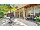 Relaxing outdoor patio with stone flooring, a dining area under an umbrella, and comfortable seating at 117 Via Roma, Woodstock, GA 30188