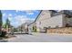 View of the townhome community featuring an attractive stone gated entrance and beautiful landscaping at 117 Via Roma, Woodstock, GA 30188