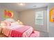 Comfortable bedroom with pink accents, plush bedding, and plenty of natural light at 8670 Brandon Hill Ln, Jonesboro, GA 30238