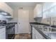 Well-lit kitchen featuring white cabinets and a stainless steel sink beneath a window at 8670 Brandon Hill Ln, Jonesboro, GA 30238
