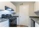 A cozy kitchen featuring a black gas stove, and white cabinets and modern fixtures at 8670 Brandon Hill Ln, Jonesboro, GA 30238