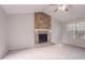 Cozy living room featuring a fireplace with stone surround and a large window for natural light at 8670 Brandon Hill Ln, Jonesboro, GA 30238