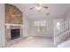 Living room featuring a stone fireplace, neutral decor, and staircase with white banister at 8670 Brandon Hill Ln, Jonesboro, GA 30238