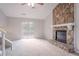 Spacious living room featuring a stone fireplace, a ceiling fan and sliding door to deck at 8670 Brandon Hill Ln, Jonesboro, GA 30238