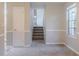 Open living space with fresh paint, showcasing a staircase and natural light from the window at 8670 Brandon Hill Ln, Jonesboro, GA 30238