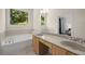 Bright bathroom featuring double sinks and a large soaking tub with a view of the green landscape outside at 106 Oakhurst Ter, Decatur, GA 30030