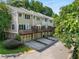 A rear view of townhomes with attached garages, private decks, and mature trees in a neighborhood at 106 Oakhurst Ter, Decatur, GA 30030