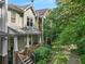 Two-story townhome with a covered porch, well-manicured bushes, and beautiful landscaping at 106 Oakhurst Ter, Decatur, GA 30030