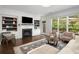 Stylish living room with a fireplace, built-in bookshelves, and large windows overlooking greenery at 106 Oakhurst Ter, Decatur, GA 30030
