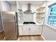 Efficient kitchen space with stainless steel appliances, white cabinets, and open shelving detail at 1872 Canmont Ne Dr, Brookhaven, GA 30319
