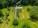 Expansive farmland and a greenhouse are showcased in this aerial shot, set amidst verdant greenery and mature trees at 220 Gamble Dr, Carrollton, GA 30116