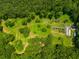 An aerial perspective highlights gardens, a greenhouse, sheds, and a diverse landscape enveloped by thick woodlands at 220 Gamble Dr, Carrollton, GA 30116