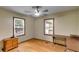 Well-lit bedroom with hardwood floors, two windows, a desk, and a dresser at 220 Gamble Dr, Carrollton, GA 30116