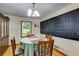 Bright dining area with a chalkboard calendar, wood floors, and natural light from the window at 220 Gamble Dr, Carrollton, GA 30116