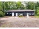 Charming black outbuilding with multiple doors and windows and minimalist landscaping for simple elegance at 220 Gamble Dr, Carrollton, GA 30116