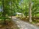 A charming home featuring a gravel drive surrounded by lush trees and foliage at 220 Gamble Dr, Carrollton, GA 30116