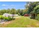 A serene view of the property featuring a greenhouse and well-maintained lawn surrounded by lush greenery at 220 Gamble Dr, Carrollton, GA 30116