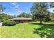 Large backyard with green grass, mature trees and view of the back of the house at 2532 Millbrook Dr, Snellville, GA 30078