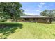 Well-maintained backyard with mature trees and view of the back of the brick house at 2532 Millbrook Dr, Snellville, GA 30078