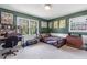 Bedroom with green walls, large windows, desk, and comfortable looking bed at 2532 Millbrook Dr, Snellville, GA 30078
