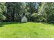 Yard with a view of the shed in the distance with lush grass and trees at 2532 Millbrook Dr, Snellville, GA 30078