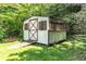 Outdoor shed with barn doors, situated on a grassy area surrounded by trees at 2532 Millbrook Dr, Snellville, GA 30078
