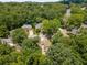 An aerial shot shows a large home nestled among mature trees in a peaceful residential neighborhood at 290 Edwardton Ct, Roswell, GA 30076