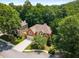 Aerial view of a brick home with mature trees surrounding the property in a lush, green neighborhood at 290 Edwardton Ct, Roswell, GA 30076