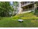 Expansive backyard with a lush lawn, trees, greenery, and steps leading to the main house at 290 Edwardton Ct, Roswell, GA 30076