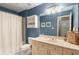 Blue toned bathroom featuring a shower and vanity with sink, counter, and storage at 290 Edwardton Ct, Roswell, GA 30076