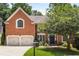 Charming brick home with a well-manicured lawn, mature tree, and a classic mailbox near a paved driveway at 290 Edwardton Ct, Roswell, GA 30076