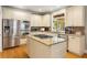 Spacious kitchen boasts stainless steel appliances, granite countertops, and a center island cooktop at 290 Edwardton Ct, Roswell, GA 30076