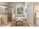 Bright main bathroom with soaking tub, glass shower, double vanity, and an exterior view at 290 Edwardton Ct, Roswell, GA 30076