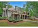 The back exterior of the home includes a porch and balcony, and well-maintained green lawn at 4435 Pemberton Cv, Johns Creek, GA 30022