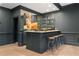 A stylish home bar features a mirrored backsplash, open shelving, and seating for four at 4435 Pemberton Cv, Johns Creek, GA 30022