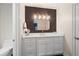 Bathroom featuring white cabinets, a mirror, and modern light fixture at 4435 Pemberton Cv, Johns Creek, GA 30022