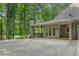 View of the house exterior with a large concrete driveway and a glimpse of the lake in the background at 4435 Pemberton Cv, Johns Creek, GA 30022