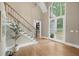 Elegant foyer featuring a staircase, grand chandelier, and leaded glass double doors, with light-filled ambiance at 4435 Pemberton Cv, Johns Creek, GA 30022