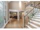 Bright foyer with hardwood floors, grand staircase, and elegant chandelier, offering a glimpse into the dining room at 4435 Pemberton Cv, Johns Creek, GA 30022