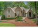 Stunning stone and stucco home with meticulously landscaped front yard in a serene wooded setting at 4435 Pemberton Cv, Johns Creek, GA 30022