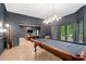 This game room features a billiard table, a seating area with a TV, and a view of the backyard at 4435 Pemberton Cv, Johns Creek, GA 30022