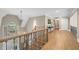 Elegant upper hallway featuring wood floors, stairs, and wrought iron railings and a view of the foyer below at 4435 Pemberton Cv, Johns Creek, GA 30022