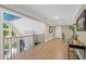 Upper level hallway featuring hardwood floors, railing, with a glimpse of the outdoors through the large window at 4435 Pemberton Cv, Johns Creek, GA 30022
