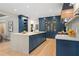 Spacious kitchen with custom blue cabinets, large island, and quartz countertops offers a modern, sophisticated design at 4435 Pemberton Cv, Johns Creek, GA 30022
