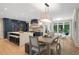 Bright kitchen and dining area with a large island, breakfast bar, stainless appliances, and access to the outdoor patio at 4435 Pemberton Cv, Johns Creek, GA 30022