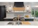 Well-equipped kitchen featuring a large range with custom hood, ample counter space, and modern design elements at 4435 Pemberton Cv, Johns Creek, GA 30022