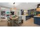 Spacious kitchen with a dining area features a large island, wood floors, custom cabinetry, and a view of the living room at 4435 Pemberton Cv, Johns Creek, GA 30022