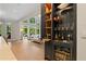 Wet bar in a spacious open-concept living room with large windows providing stunning views at 4435 Pemberton Cv, Johns Creek, GA 30022