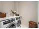 A well lit, modern laundry room features an Electrolux washer and dryer, a countertop, and storage at 4435 Pemberton Cv, Johns Creek, GA 30022