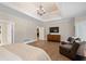 This spacious main bedroom features a sitting area, hardwood floors, and a large tv at 4435 Pemberton Cv, Johns Creek, GA 30022